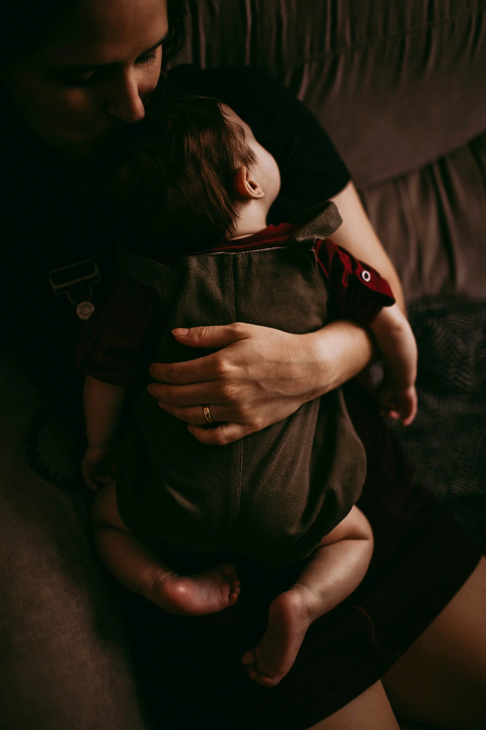 Eine Person hält ein friedlich schlafendes Baby zärtlich im Arm.