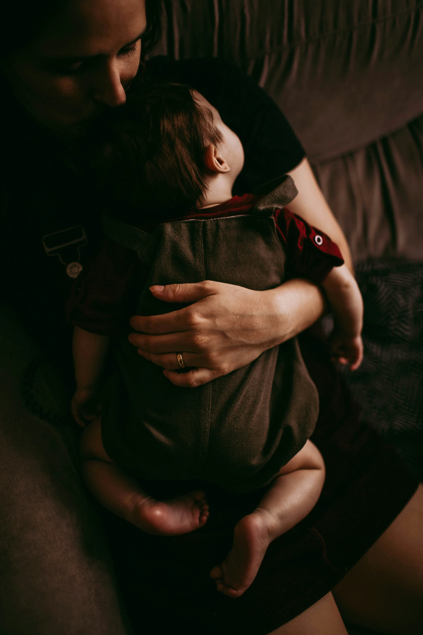 Eine Person hält ein friedlich schlafendes Baby zärtlich im Arm.